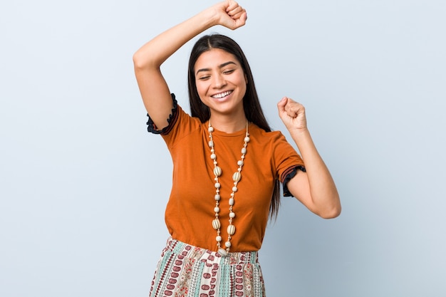 Jonge Arabische vrouw die een speciale dag viert, springt en heft de armen op met energie.