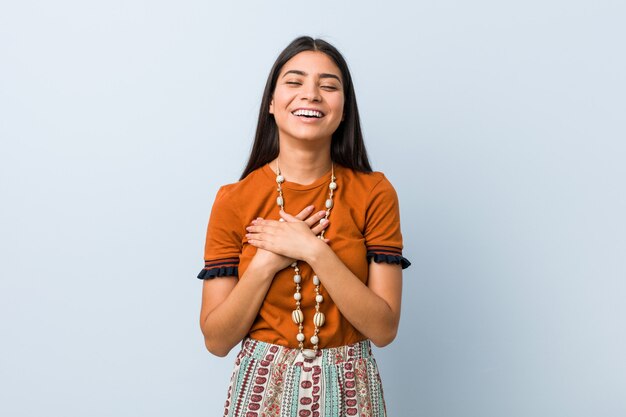 Jonge Arabische vrouw die houdend handen op hart lachen, concept geluk.