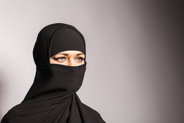 Jonge arabische vrouw in hijab of niqab.