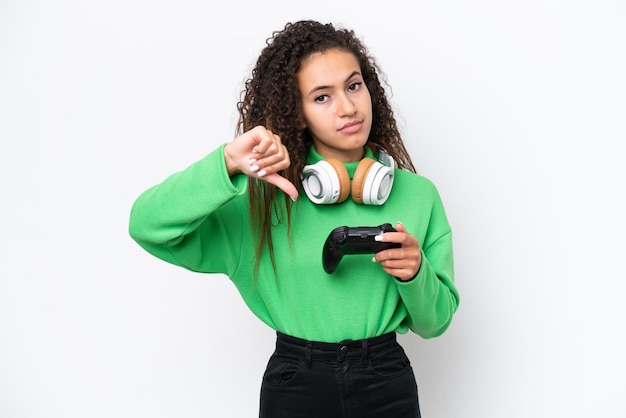 Jonge Arabische vrouw spelen met een video game controller geïsoleerd op een witte achtergrond met duim omlaag met negatieve expression