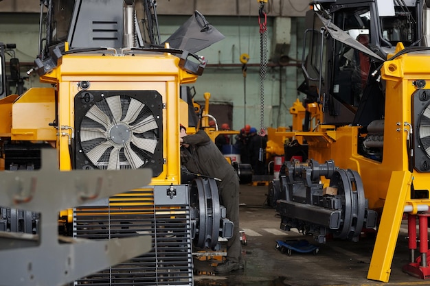 Jonge arbeider van moderne fabriek die technische controle van machine maakt