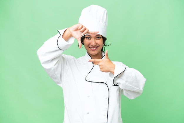 Jonge Argentijnse chef-kok vrouw op een geïsoleerde achtergrond met het gezicht in het kader van het symbool