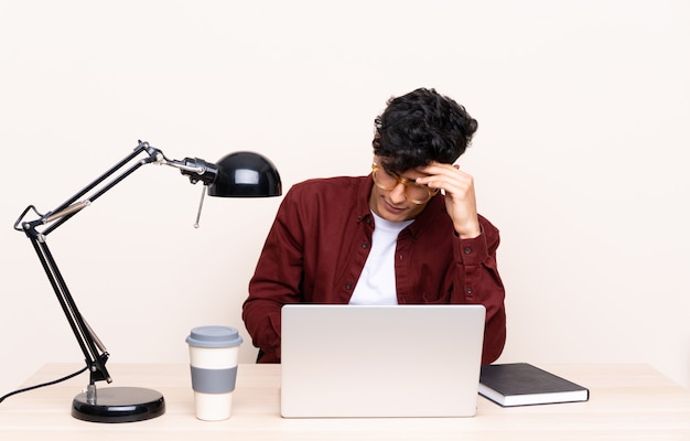 Jonge Argentijnse man in een tafel met een laptop op zijn werkplek