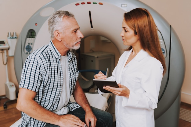 Foto jonge arts grootvader voor mri-scan voorbereiden.