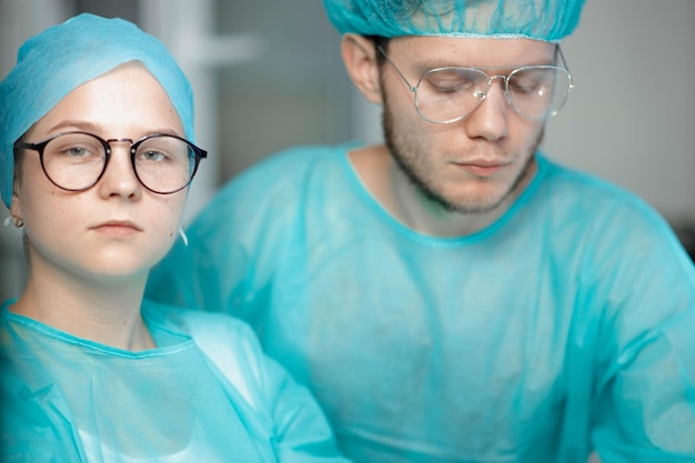 Foto jonge artsencollega's werken en studeren achter de computer mannelijke en vrouwelijke chirurgen in uniform zijn stu