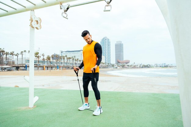 Jonge atleet die 's ochtends traint op het strand van de sportschool