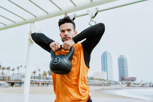 Jonge atleet die 's ochtends traint op het strand van de sportschool