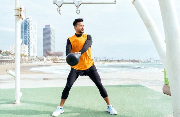 Jonge atleet die 's ochtends traint op het strand van de sportschool