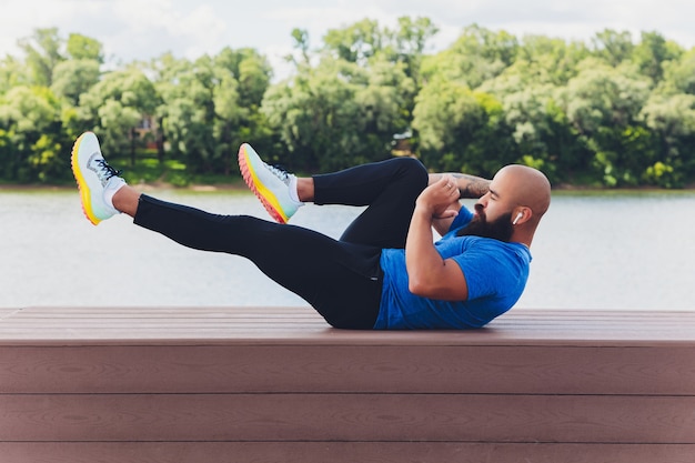 Jonge atleet die snel buiten loopt. sportdoek dragen, brede stap doen, gezonde manier van leven demonstreren, breed schot.