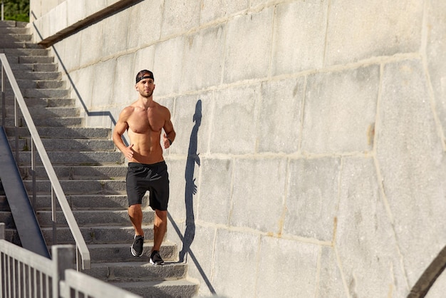 Jonge atleet doet ochtendrennen man rent de trap op en doet cardio-oefeningen