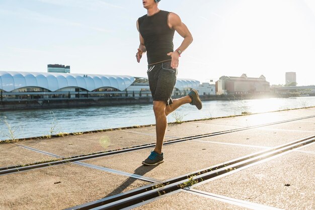 Foto jonge atleet joggen in de stad aan de rivier