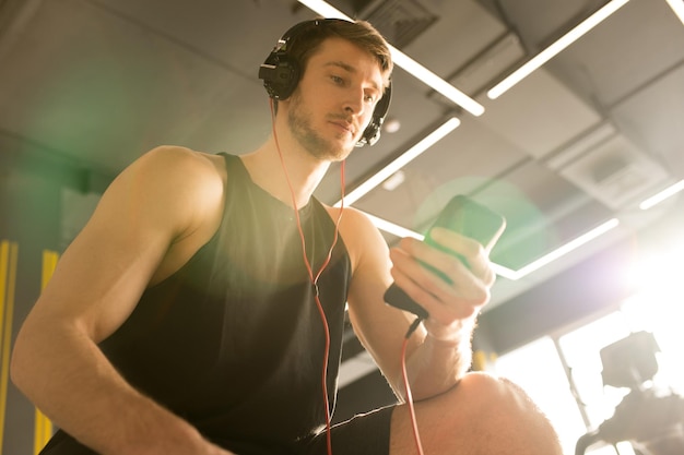 Jonge atleet met behulp van telefoon op training