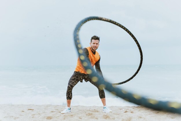 Jonge atleet traint 's ochtends op het strand met touwen