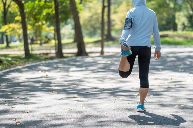 Jonge atletenvrouw streching in het park openlucht