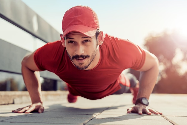 Jonge atletische man die pushups doet