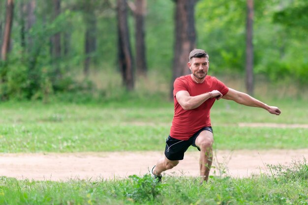 Jonge atletische man die zich buiten uitstrekt