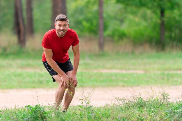 Jonge atletische man die zich buiten uitstrekt