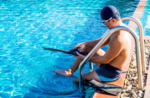 Jonge atletische man met flippers bij het zwembad