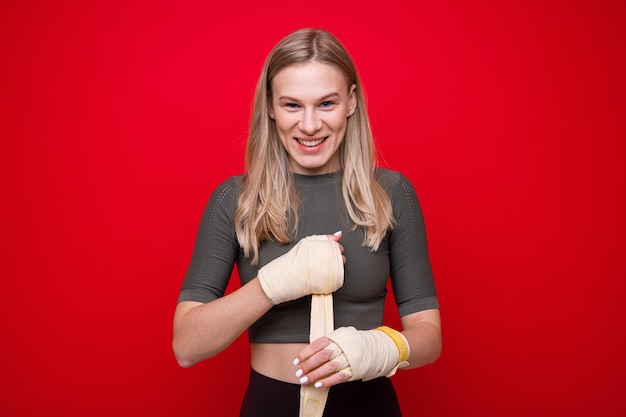 Jonge atletische vrouw verbindt haar handen voordat bokstraining