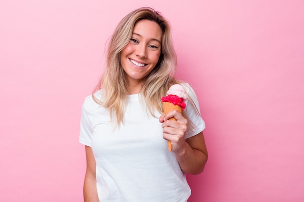 Jonge Australische vrouw met een ijsje geïsoleerd op roze achtergrond gelukkig, glimlachend en vrolijk.