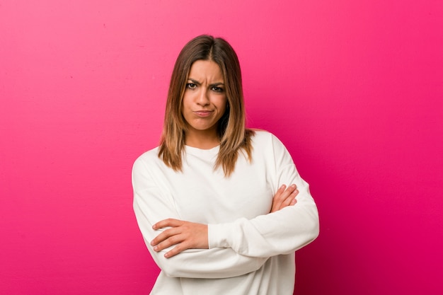 Jonge authentieke charismatische echte mensenvrouw tegen muur het ongelukkige kijken in camera met sarcastische uitdrukking.