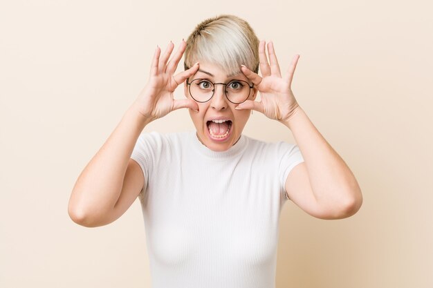 Jonge authentieke natuurlijke vrouw die een wit overhemd draagt dat ogen houdt geopend om een succeskans te vinden.