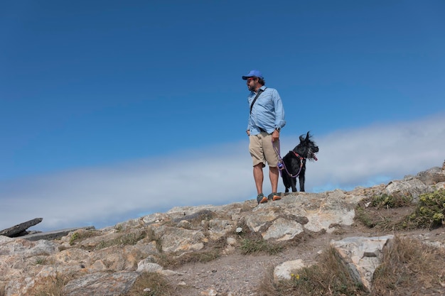 Jonge avonturier loopt langs de klif met zijn hond