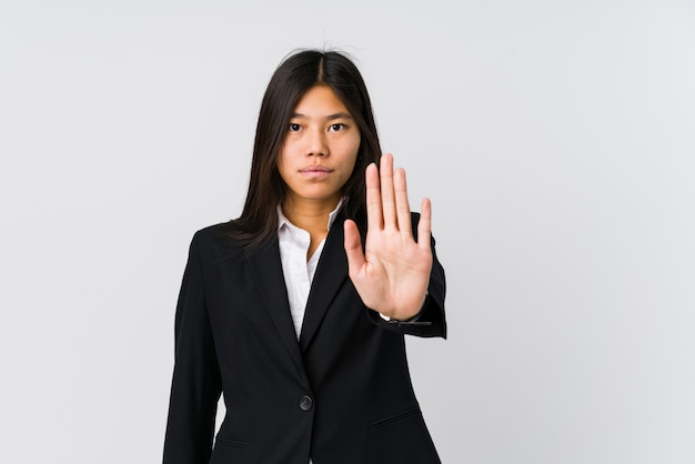 Jonge aziatische bedrijfsvrouw die zich met uitgestrekte hand bevindt die eindeteken toont, dat u verhindert.