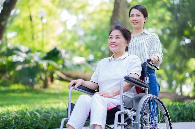 Jonge Aziatische dochter zorgt voor haar gehandicapte moeder