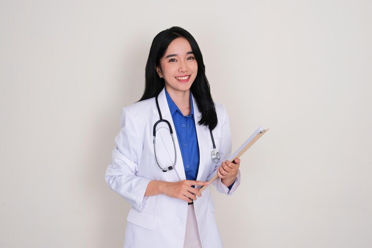 Foto jonge aziatische dokter glimlacht vriendelijk naar de camera.