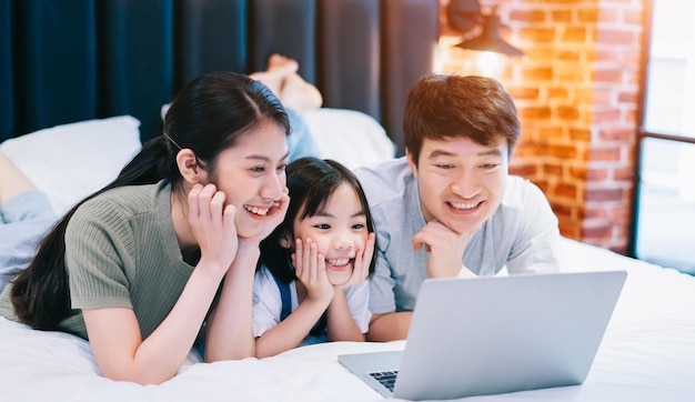 Jonge Aziatische familie op het bed