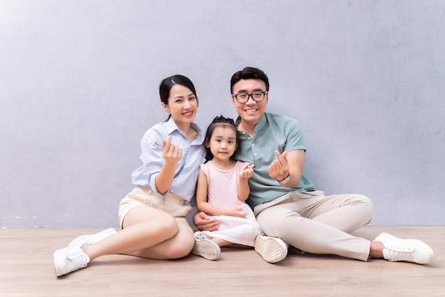 Jonge Aziatische familie zittend op de vloer