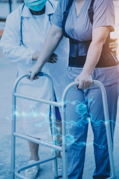 Jonge aziatische fysiotherapeut die met een oudere vrouw werkt aan het lopen met een rollator