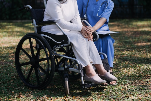 Jonge aziatische fysiotherapeut die met een oudere vrouw werkt aan het lopen met een rollator