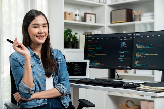 Jonge Aziatische IT-ontwikkelaar kijkt naar de camera om te presenteren op pc Stratagem