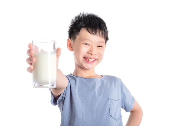 Jonge Aziatische jongen die een glas melk over witte achtergrond houdt