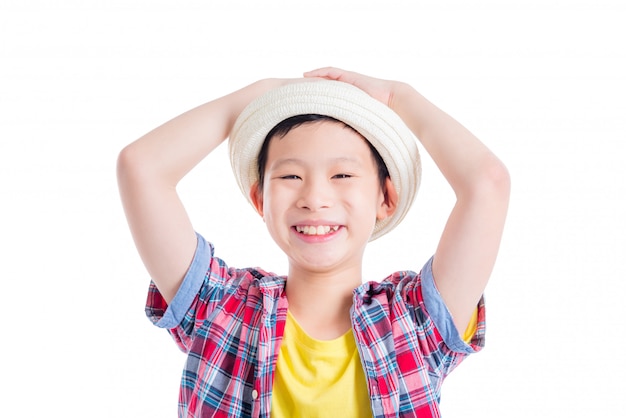 Jonge Aziatische jongen die hoed en glimlachen over witte achtergrond draagt
