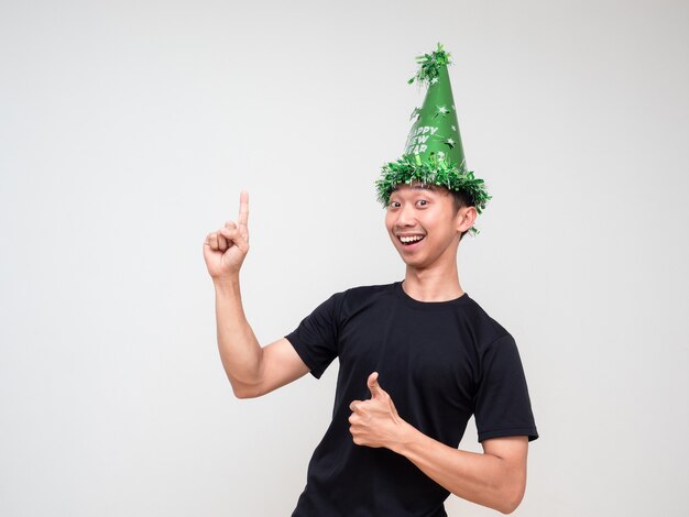 Jonge Aziatische man blij gezicht kijken camera met groene hoed wijs rechter vinger boven duim omhoog