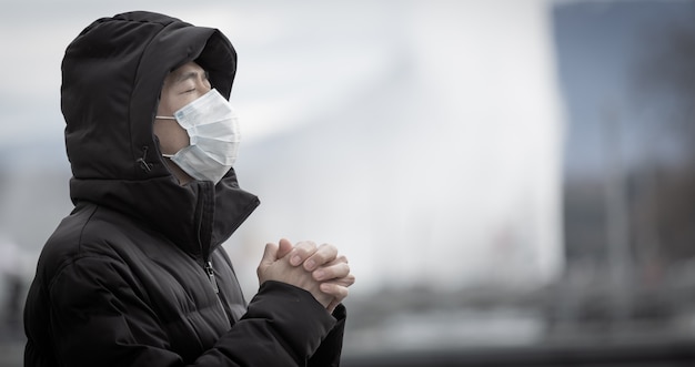 jonge Aziatische man die een masker draagt om ziektekiemen, giftige dampen en stof te voorkomen