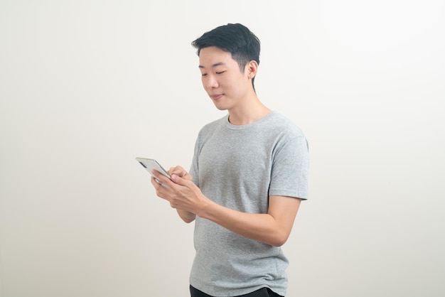 jonge Aziatische man die smartphone en mobiele telefoon gebruikt of praat op een witte achtergrond