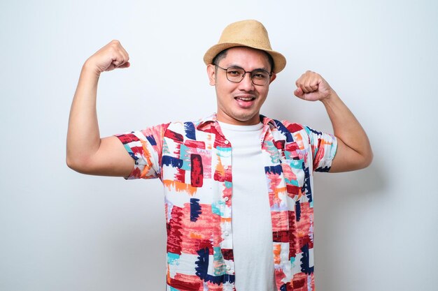 Jonge aziatische man die wapenspieren toont die trots fitnessconcept glimlachen
