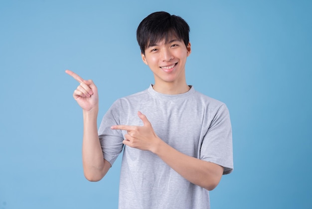 Jonge Aziatische man die zich voordeed op blauwe achtergrond