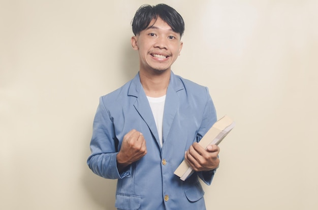 Jonge Aziatische man dragen college pak met uitdrukking toont enthousiasme op geïsoleerde achtergrond