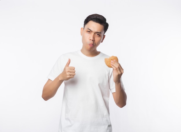 Jonge Aziatische man in wit t-shirt hamburger eten