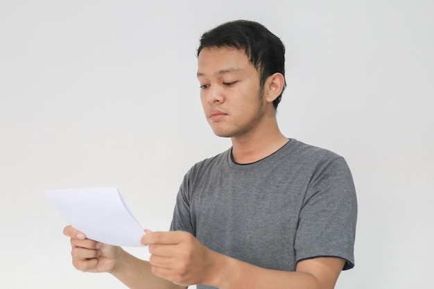 Jonge Aziatische man leest het witboek-e-mailbericht of de rekening