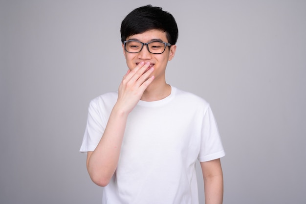 jonge Aziatische man met bril op wit