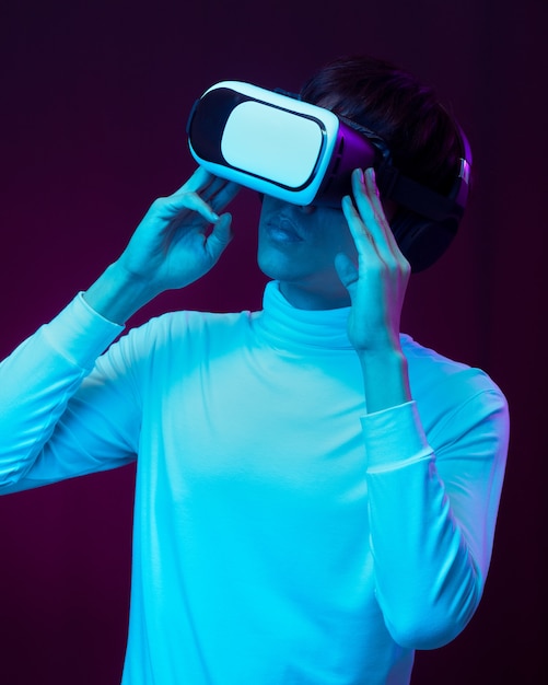 Jonge aziatische man met een virtual reality-bril die 360 graden video kijkt in neonlicht, technologieconcept