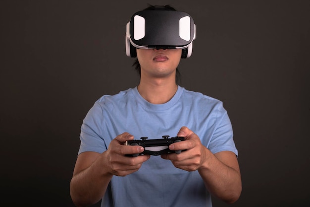 Jonge Aziatische man met een VR-bril tijdens het spelen van videogames