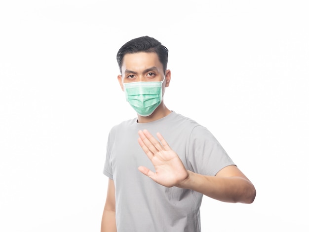 Jonge Aziatische man met hygiënische masker gebaren stop om infectie, 2019-nCoV of coronavirus te voorkomen. Luchtwegaandoeningen zoals PM 2,5 vechten en griep geïsoleerd