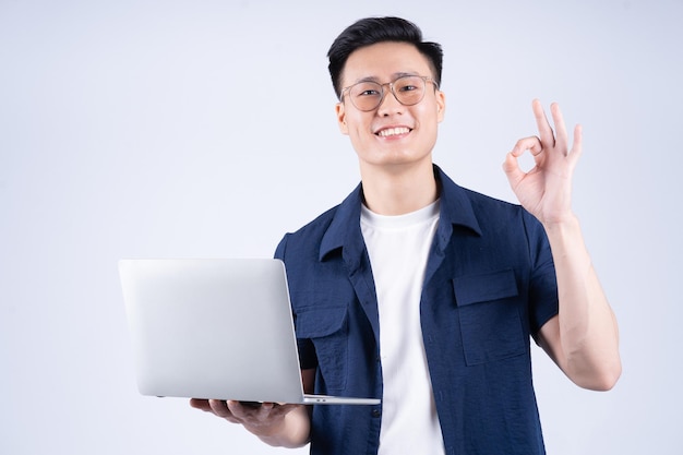 Jonge Aziatische man met laptop op witte achtergrond